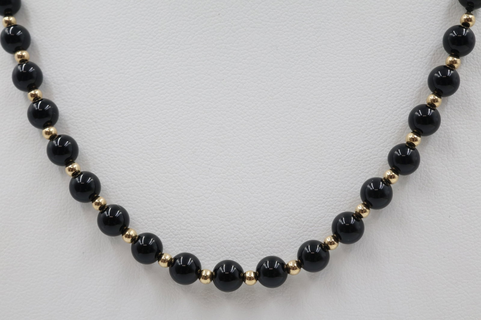 Onyx Bead Necklace with 14k Gold Clasp: 16-inch necklace featuring 51 polished onyx beads finished with a 14K gold clasp. Total weight: 16.6 grams.