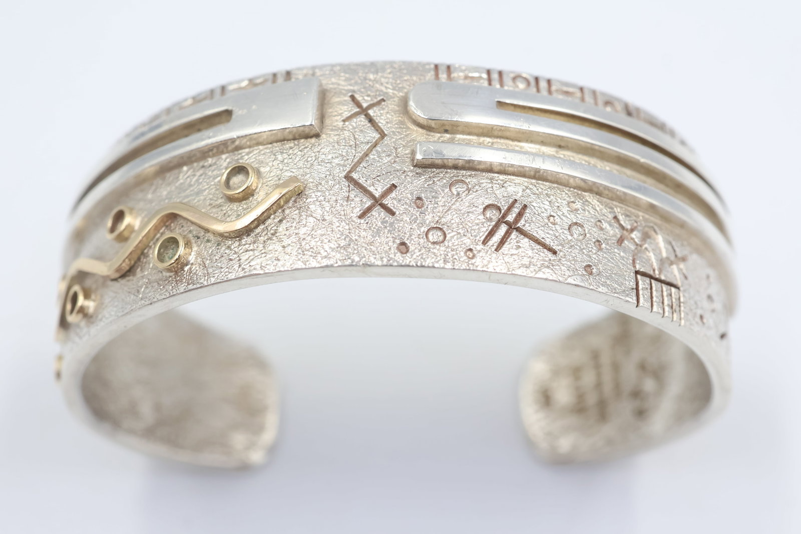 Zuni Sterling Silver Cuff Bracelet: Zuni cuff bracelet crafted in sterling silver and accented with 14K yellow gold. A striking piece showcasing traditional Southwestern-inspired craftsmanship and timeless appeal. Fits a 5 1/4" wrist.