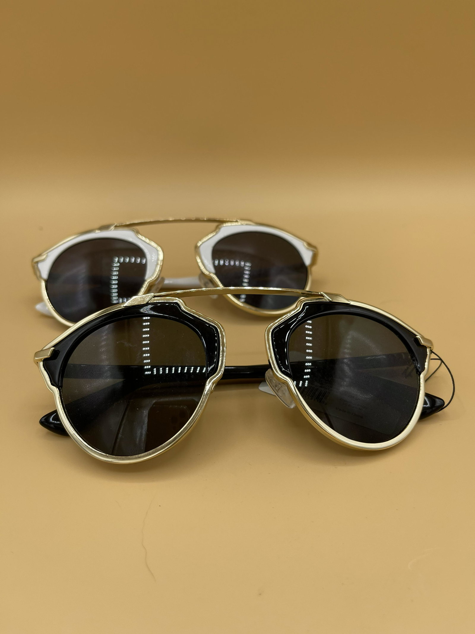 2 Pairs Designer Inspired Sunglasses: Designer inspired Black and White sunglasses with gold tones. One still has the tags attached.