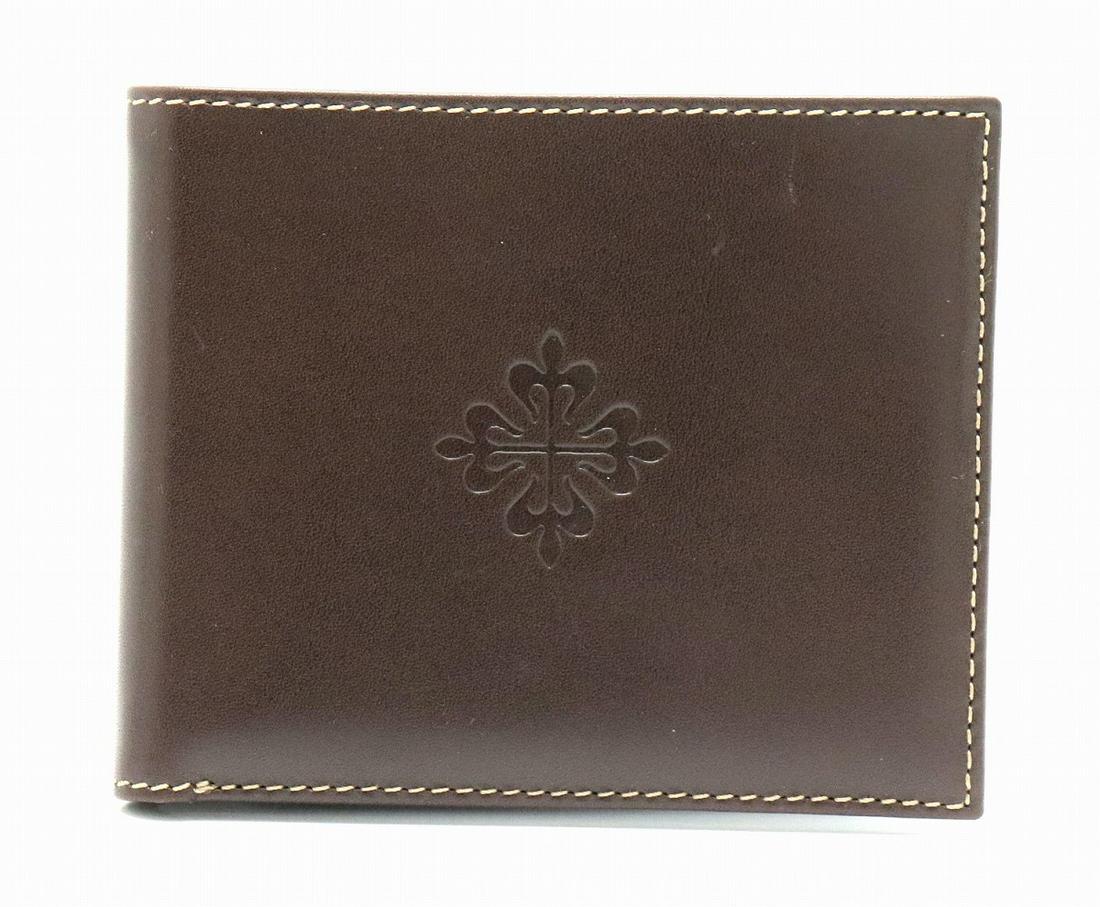 Authentic Patek Philippe two-fold wallet leather dark: This item qualifies for FREE DOMESTIC SHIPPING to customers in the USA Brand: Patek Philippe Type: Wallet (bi-fold) Material: Leather Color: Dark brown Size (HxWxD): 9cm x 11cm / 3.54'' x 4.33'' Condi