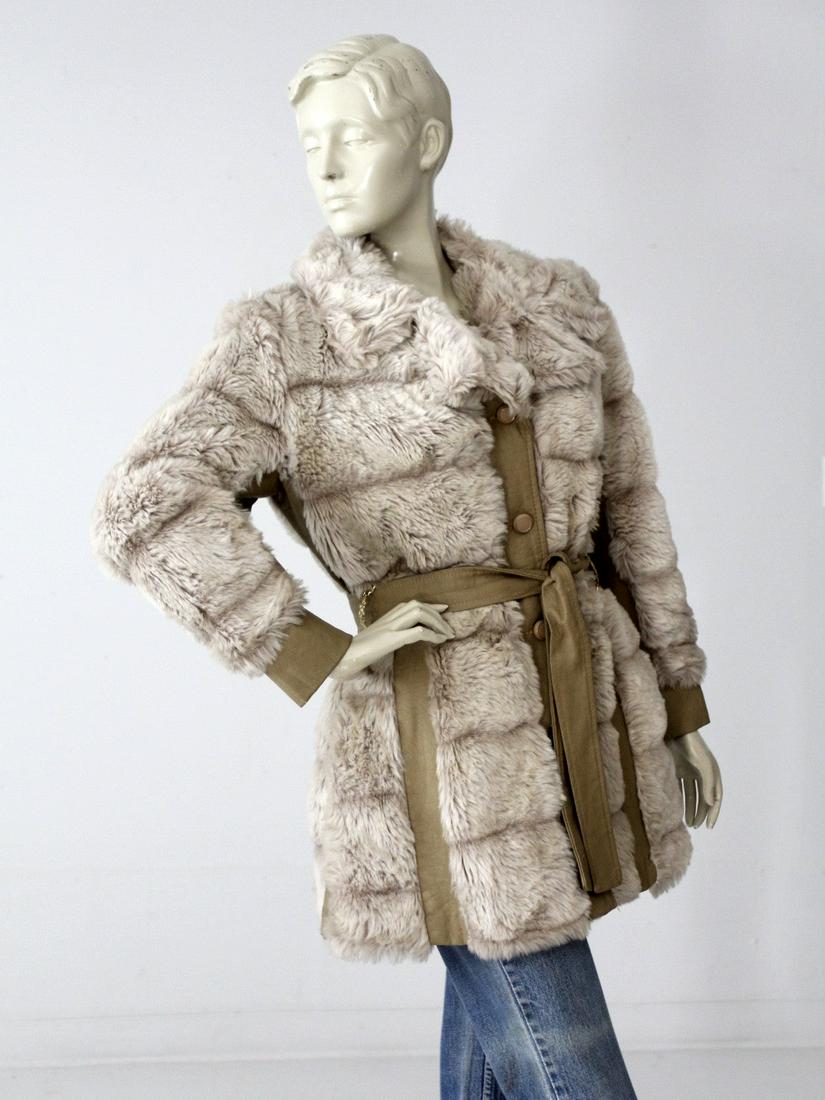 Vintage 70S Faux Fur Belted Coat: Vintage 70S Faux Fur Belted Coat This is a 1970s vintage faux fur and leather belted jacket. Plush cream and gray faux fur shapes the jacket with taupe faux fur paneling. A faux leather belt cinches t