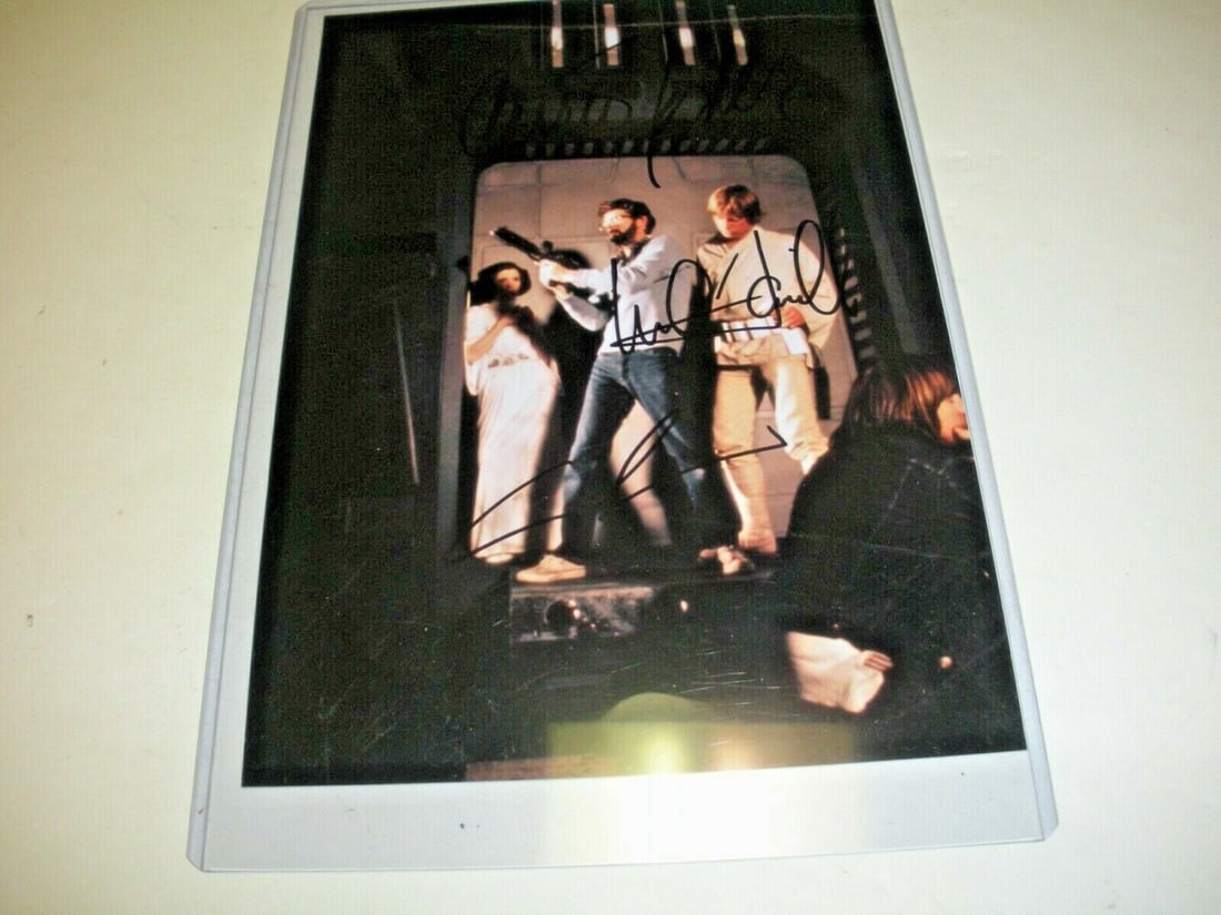MARK HAMILL CARRIE FISHER GEORGE LUCAS STAR WARS W/COA SIGNED PHOTO: MARK HAMILL CARRIE FISHER GEORGE LUCAS STAR WARS W/COA SIGNED PHOTO Pre-Owned While the lot images are representative of the item, the size, placement and strength of the signature may vary. Each item