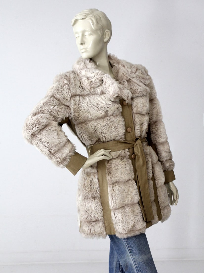 Vintage 70S Faux Fur Belted Coat: Vintage 70S Faux Fur Belted Coat This is a 1970s vintage faux fur and leather belted jacket. Plush cream and gray faux fur shapes the jacket with taupe faux fur paneling. A faux leather belt cinches t