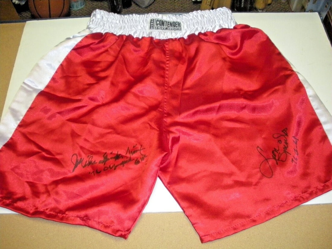 LEON SPINKS MICHAEL SPINKS 1976 OLYMPIC GOLD MEDAL SIGNED BOXING TRUNKS: LEON SPINKS MICHAEL SPINKS 1976 OLYMPIC GOLD MEDAL SIGNED BOXING TRUNKS Authentic boxing trunks signed by Leon Spinks and Michael Spinks, commemorating their achievement at the 1976 Olympic Games wher