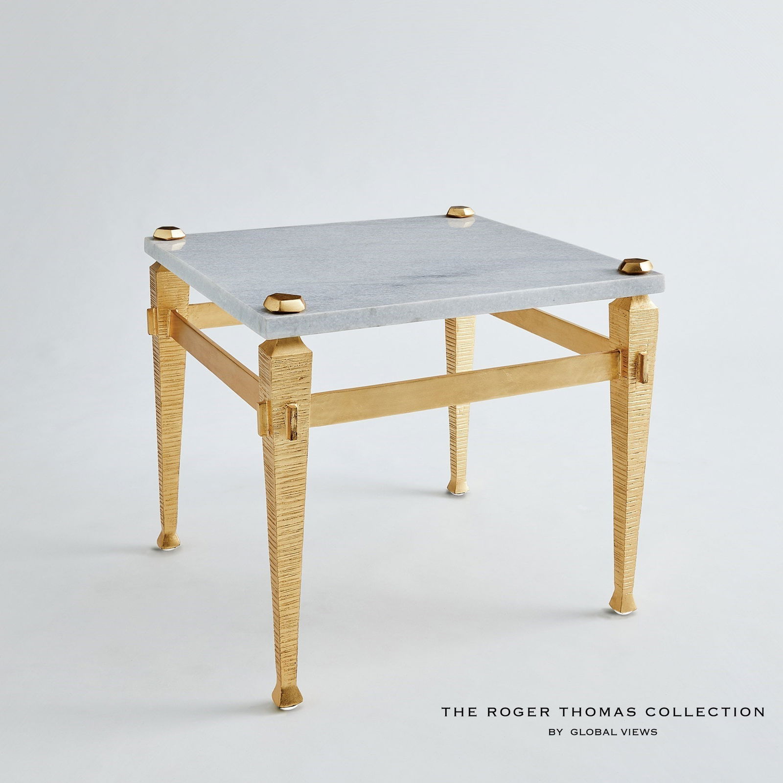 Roman End Table In Gold: Roman End Table In Gold The Roman collection by Roger Thomas draws inspiration from two notable sources. The silhouette of the leg was inspired by pieces crafted by Thomas Chippendale. The horizontal