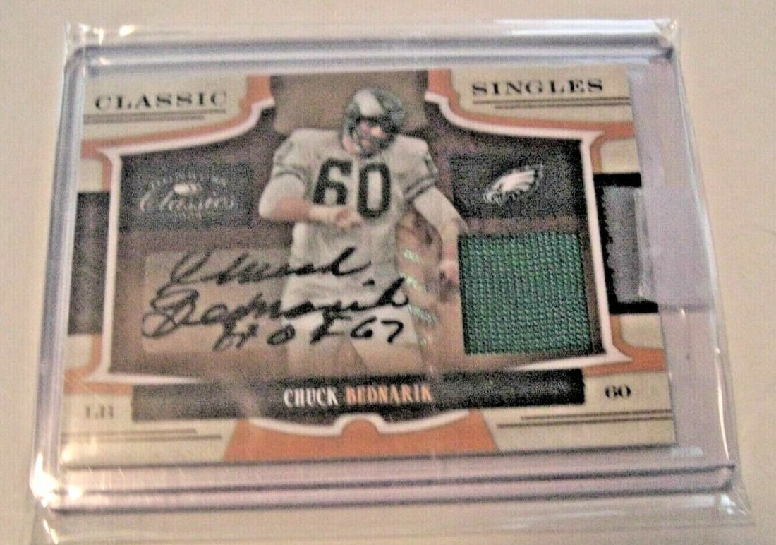 Chuck Bednarik 2009 Donruss Classics Signed Game Used Jersey Card 19 of 25: Chuck Bednarik 2009 Donruss Classics Signed Game Used Jersey Card 19 of 25 This item is a CHUCK BEDNARIK 2009 DONRUSS CLASSICS GAME USED JERSEY AUTO 19/25 SIGNED CARD, showcasing a piece of memorabili