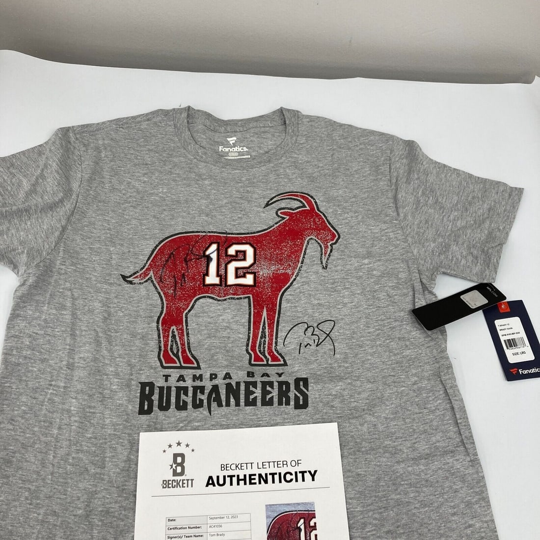Tom Brady Signed Tampa Bay Buccaneers GOAT Fanatics T-Shirt Beckett COA: Tom Brady Signed Tampa Bay Buccaneers GOAT Fanatics T-Shirt Beckett COA Sport: Football Player: Tom Brady Signed: Yes Original/Reprint: Original Autograph Authentication: Beckett Authentication Servic