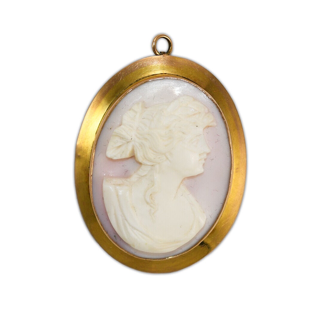 10K Yellow Gold Antique Shell Cameo Pendant/PIN 1 5/8 x 1 1/4 inches: 10K Yellow Gold Antique Shell Cameo Pendant/PIN 1 5/8 x 1 1/4 inches This exquisite antique shell cameo features a hand-carved profile of a woman in ivory against a delicate pink background. Set in a