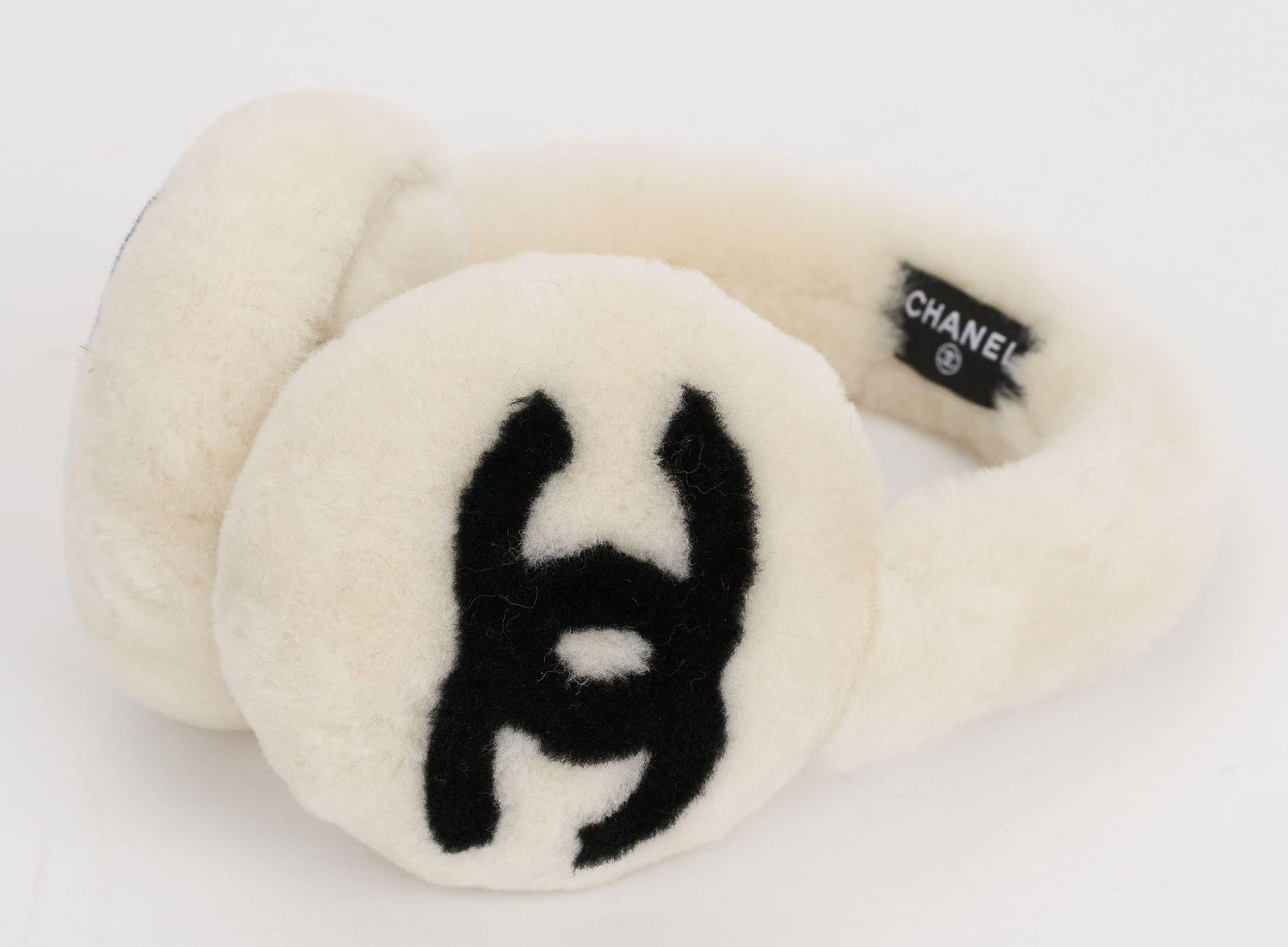 Chanel Off White Fur Logo Earmuffs Made in Italy: Chanel Off White Fur Logo Earmuffs Made in Italy These Chanel earmuffs are crafted from luxurious off-white fur, showcasing a prominent logo. They measure 4.5 in (11.43 cm) in height and width, with a
