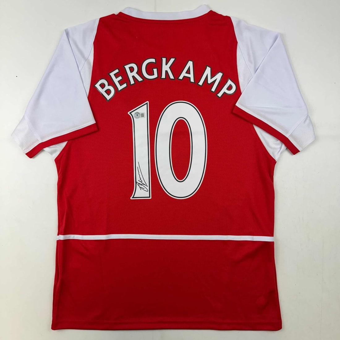 Autographed Dennis Bergkamp Arsenal Red Jersey Premier League Beckett COA: Autographed Dennis Bergkamp Arsenal Red Jersey Premier League Beckett COA This is an authentic red soccer jersey autographed by legendary Arsenal player Dennis Bergkamp. The jersey is from the Premier