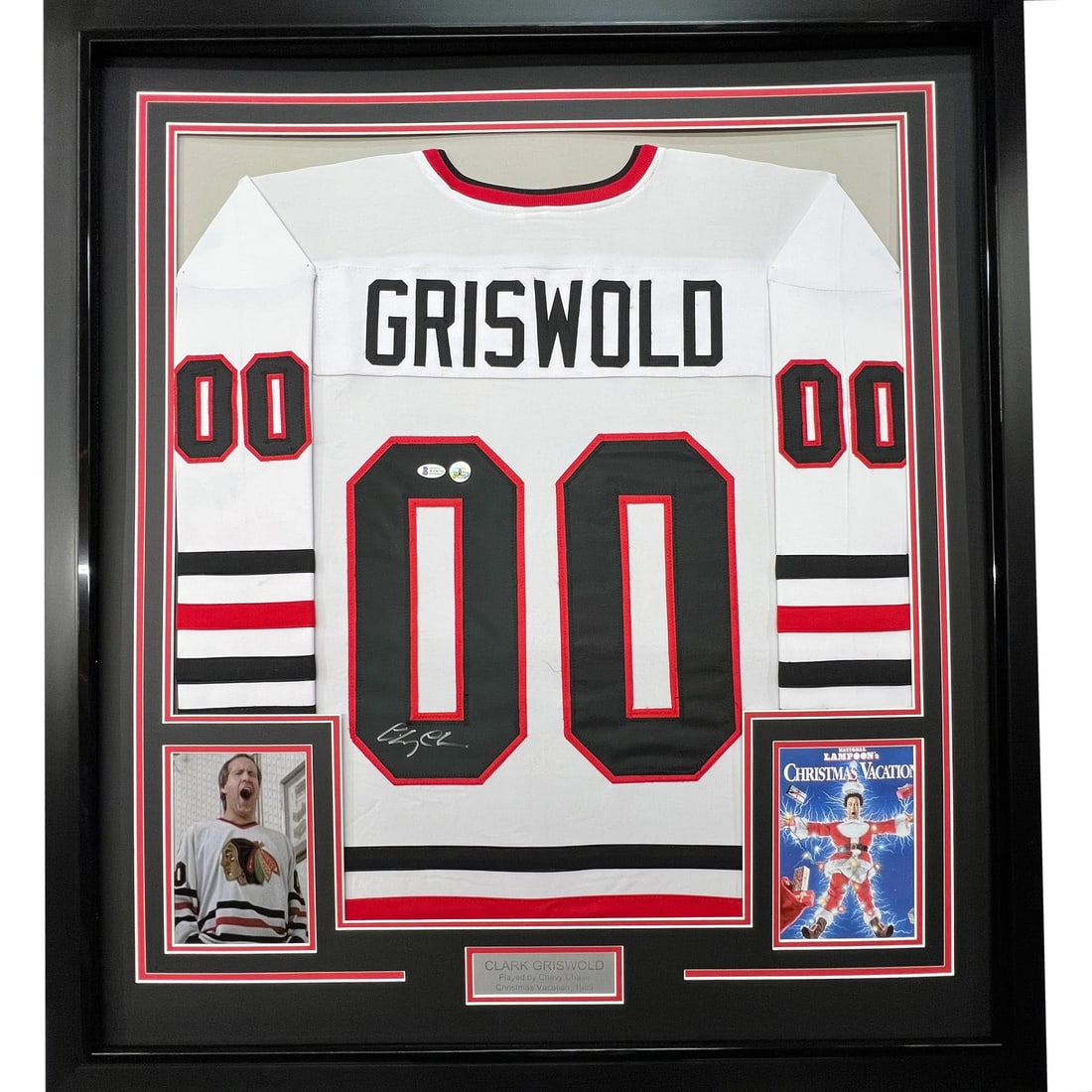 FRAMED Autographed/Signed CHEVY CHASE 33x42 White Jersey BAS COA: FRAMED Autographed/Signed CHEVY CHASE 33x42 White Jersey BAS COA This stunning framed jersey commemorates Chevy Chase's iconic role as Clark Griswold, showcasing a 'GRISWOLD' nameplate and number '00'