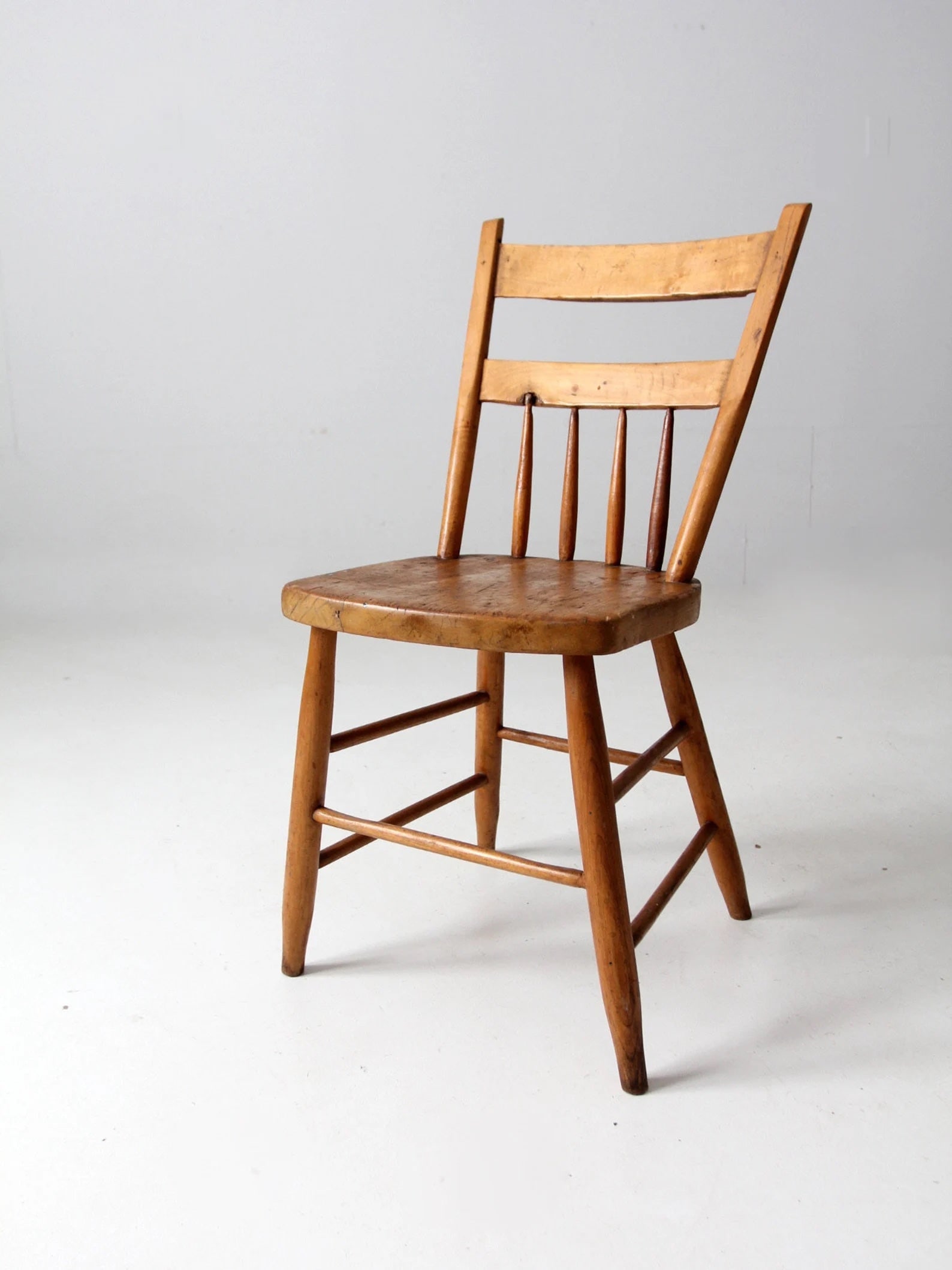 Antique Primitive Farmhouse Chair: Antique Primitive Farmhouse Chair This antique primitive farmhouse chair embodies rustic charm with its sturdy wooden construction and beautiful natural honey tone. The chair features a plank seat and
