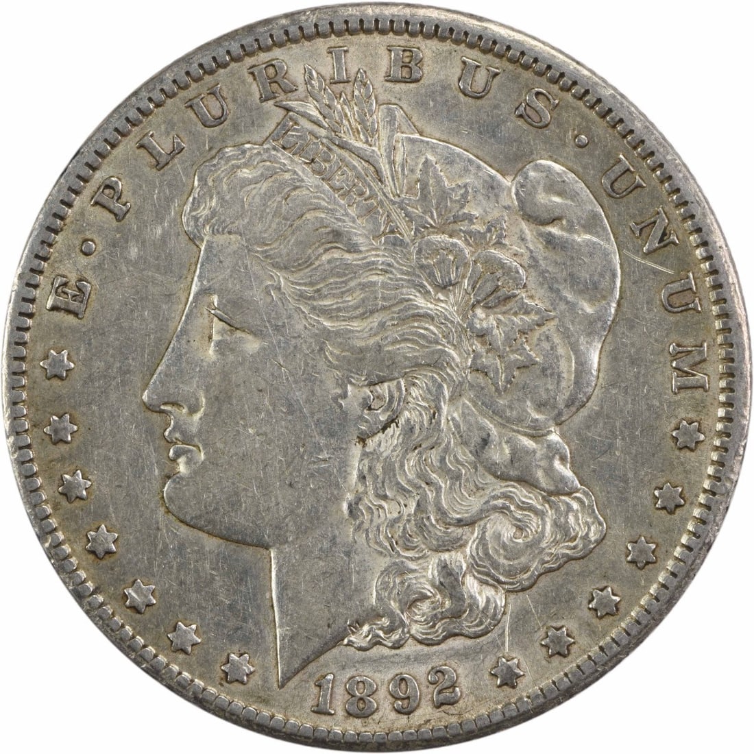 1892-CC Morgan Silver Dollar AU Uncertified Silver Coin: 1892-CC Morgan Silver Dollar AU Uncertified Silver Coin This 1892-CC Morgan Silver Dollar is a remarkable piece of numismatic history, featuring a design by George T. Morgan. With a grade of AU, this