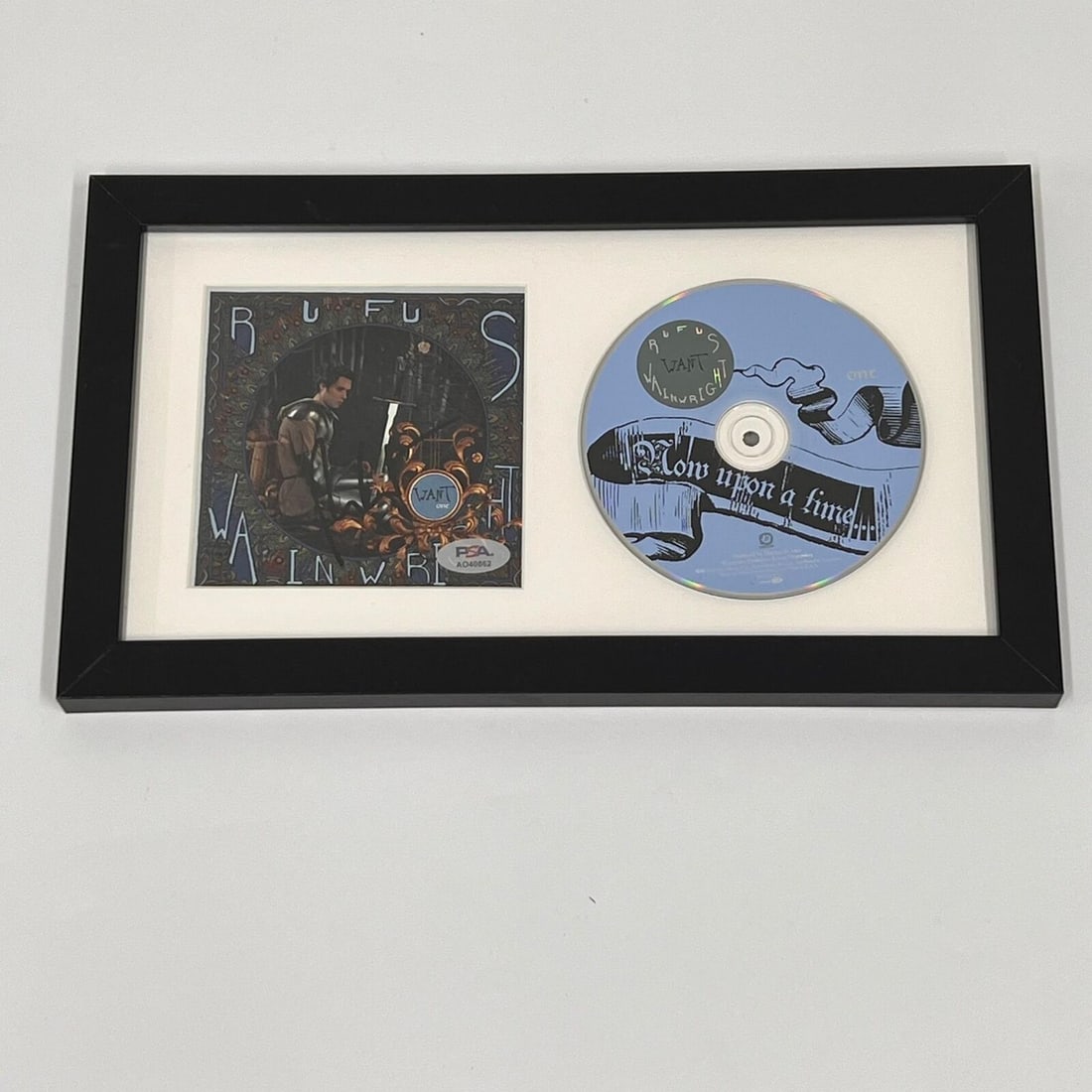 Rufus Wainwright Signed Now Upon a Time CD Cover Framed PSA/DNA: Rufus Wainwright Signed Now Upon a Time CD Cover Framed PSA/DNA This listing features a framed CD cover of Rufus Wainwright's 'Now Upon a Time,' personally signed by the artist. The autograph has been