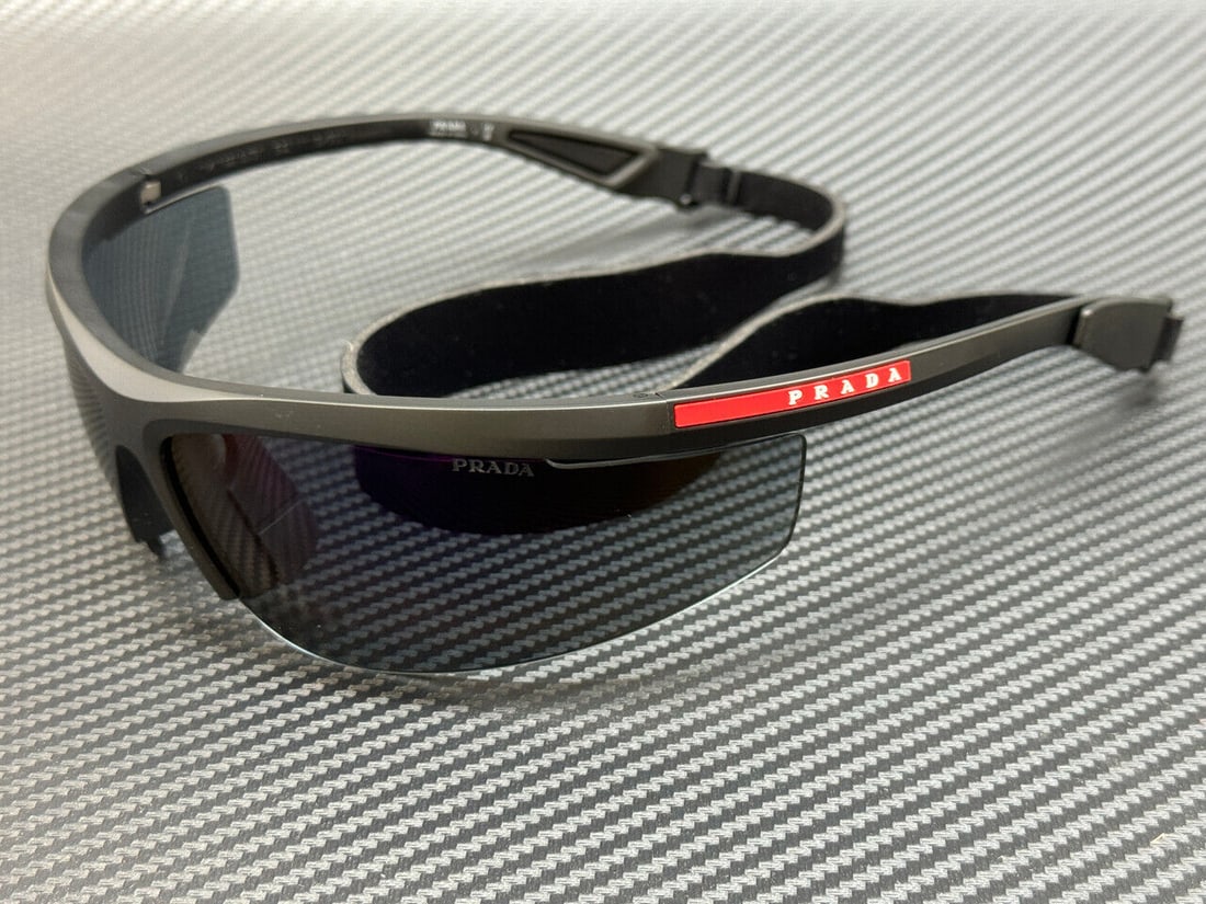 Prada Linea Rossa PS A02S 1BO10J Matte Black Sunglasses with Blue Mirror Violet Lenses: Prada Linea Rossa PS A02S 1BO10J Matte Black Sunglasses with Blue Mirror Violet Lenses Introducing the PRADA LINEA ROSSA PS A02S 1BO10J sunglasses, featuring a sleek matte black frame complemented by