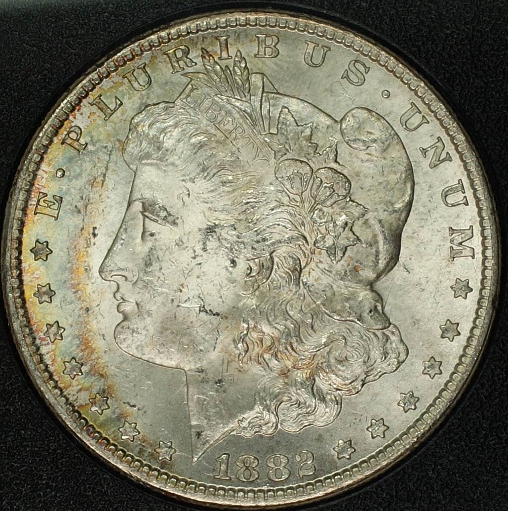 1882-CC Morgan Silver Dollar ANACS MS 63 Toned with Box & COA: 1882-CC Morgan Silver Dollar ANACS MS 63 Toned with Box & COA This 1882-CC Morgan Silver Dollar is certified by ANACS with a grade of MS 63, indicating it is in uncirculated condition. Minted in Carso