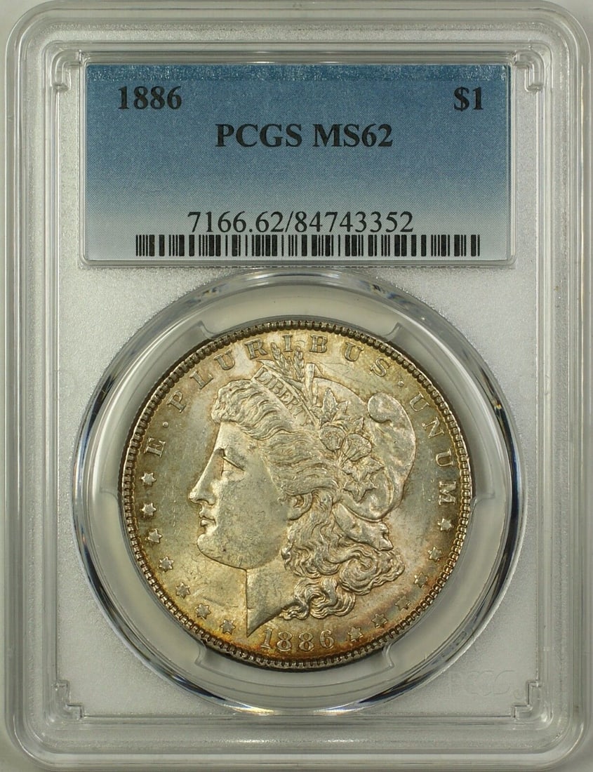 1886 Morgan Silver Dollar Coin PCGS MS62 Uncirculated Silver: 1886 Morgan Silver Dollar Coin PCGS MS62 Uncirculated Silver This 1886 Morgan Silver Dollar $1 Coin is a stunning addition for any numismatist or collector. Graded MS 62 by PCGS, this uncirculated coi