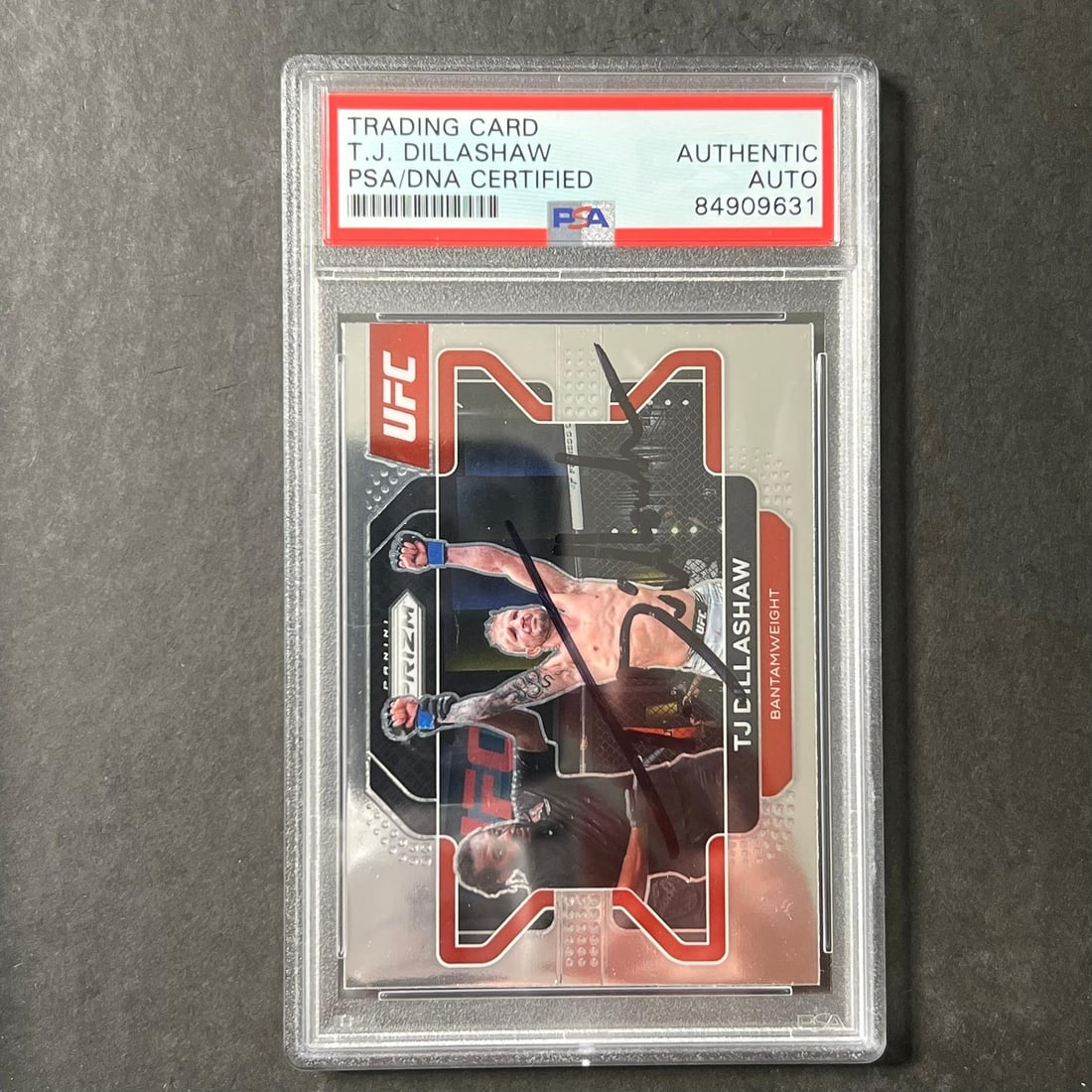 2022 Panini Prizm UFC #12 T.J. Dillashaw Signed Card PSA/DNA Authenticated: 2022 Panini Prizm UFC #12 T.J. Dillashaw Signed Card PSA/DNA Authenticated This collectible features a 2022 Panini Prizm UFC #12 card, personally signed by T.J. Dillashaw. The autograph has been authe