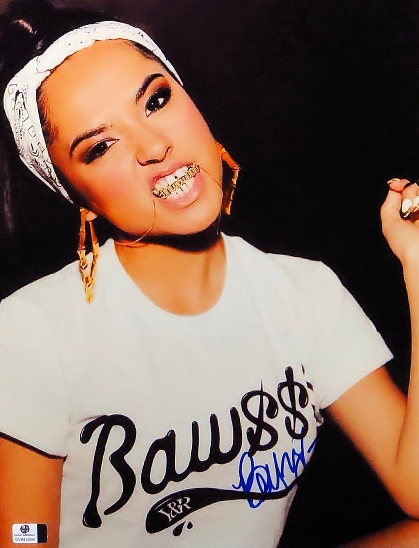 Becky G Autographed 11X14 Original Photo with Chain Iconic Pose: Becky G Autographed 11X14 Original Photo with Chain Iconic Pose Capture a moment in music history with this autographed 11X14 photograph of Becky G, featuring her iconic pose with a chain in her mouth