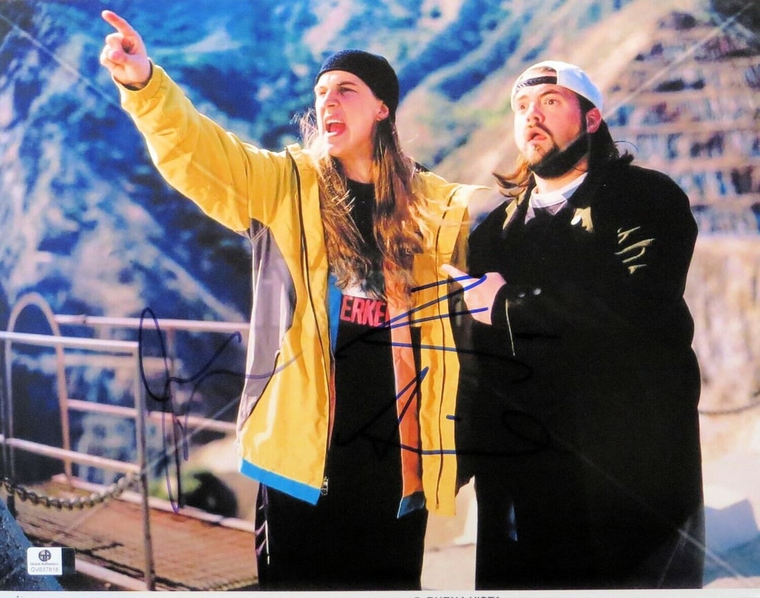 Kevin Smith Jason Mewes Autographed 11x14 Photo GAI Certified: Kevin Smith Jason Mewes Autographed 11x14 Photo GAI Certified This is an authentic 11x14 photograph featuring Kevin Smith and Jason Mewes, known for their iconic roles as Jay and Silent Bob. Both sign