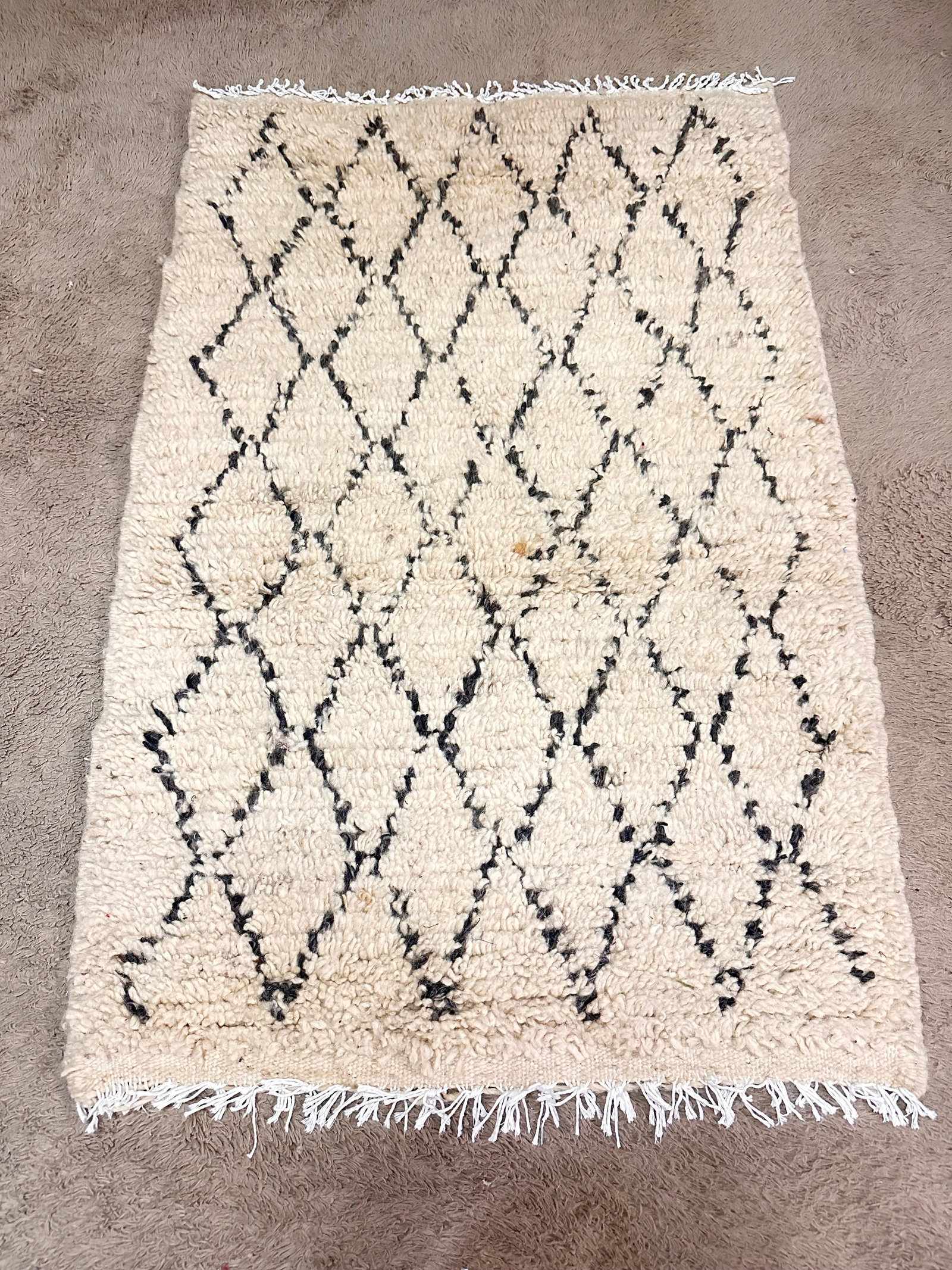 Handmade Moroccan Amazigh Wool Rug 28" x 43.5": Handmade Moroccan Amazigh Wool Rug 28" x 43.5" Discover the beauty of Moroccan craftsmanship with this authentic handmade Amazigh rug. Skillfully woven by Amazigh women in the Atlas Mountains, this ru
