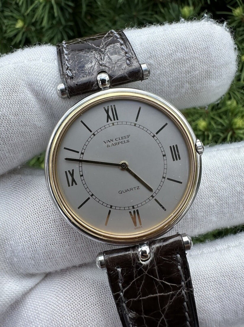 Van Cleef & Arpels La Collection 32mm Quartz Watch Gold Bezel Gray Dial: Van Cleef & Arpels La Collection 32mm Quartz Watch Gold Bezel Gray Dial This stunning Van Cleef & Arpels "La Collection" wristwatch features a classic round shape with a 32 mm stainless steel case. Th