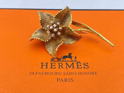HERMES 18K Gold Diamond Ruby Flower Brooch with Box: HERMES 18K Gold Diamond Ruby Flower Brooch with Box This exquisite HERMES 18K yellow gold brooch features a stunning flower design adorned with diamonds and a ruby accent. Fully signed, numbered,
