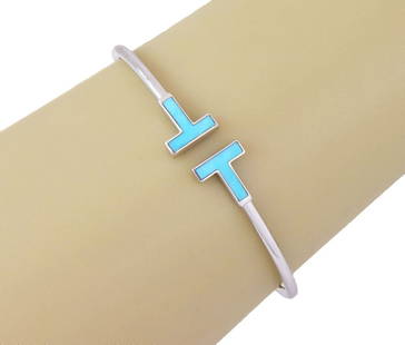 Tiffany T Wire Turquoise 18k White Gold Cuff Bracelet: Tiffany T Wire Turquoise 18k White Gold Cuff Bracelet Elevate your jewelry collection with the Tiffany T Wire bracelet, a stunning display of luxury and craftsmanship from Tiffany & Co. This exquisite