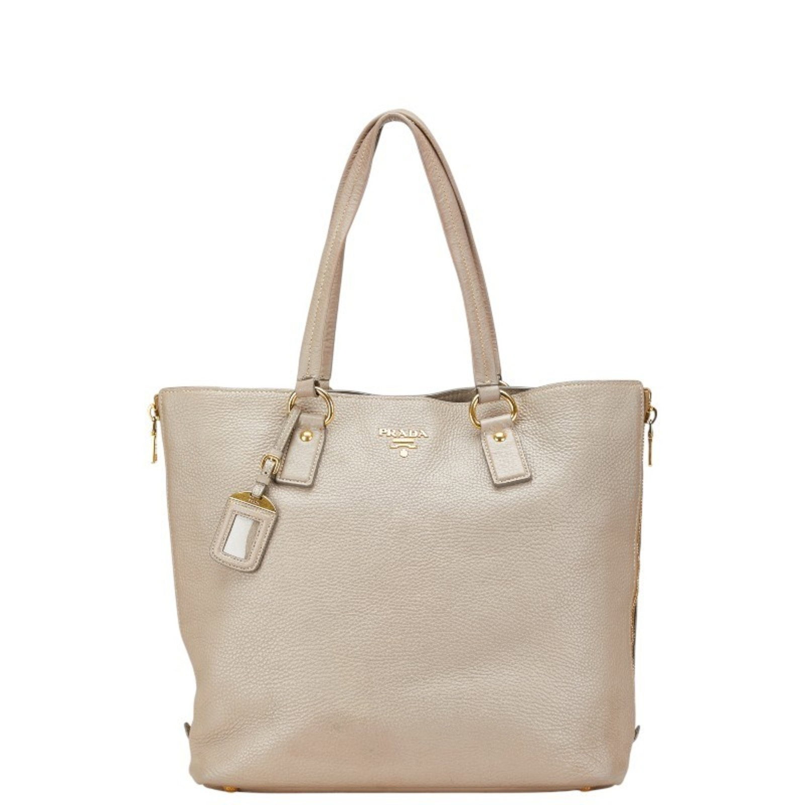 Prada Beige Greige Leather Tote Bag for Women: Prada Beige Greige Leather Tote Bag for Women This stylish Prada Tote Bag is crafted from high-quality leather in a chic beige and grayish color combination. Designed for women, it features a spacious