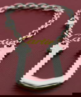 Cartier U Silver Stainless Steel Key Ring 43mm with Box: Cartier U Silver Stainless Steel Key Ring 43mm with Box This Cartier U Key Ring is a stylish accessory crafted from high-quality stainless steel, featuring a sleek silver finish that exemplifies luxur