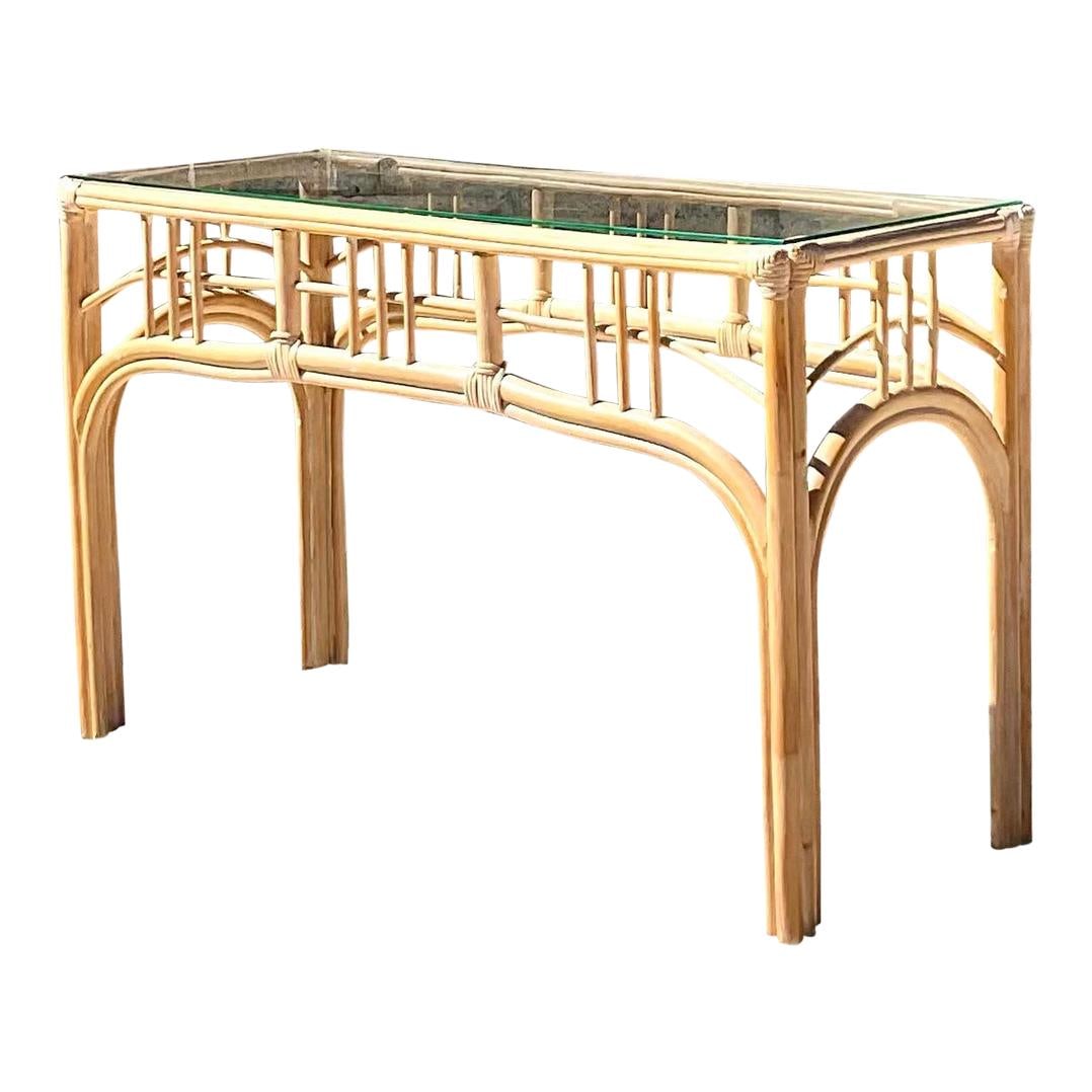 Gorgeous Vintage Coastal Rattan Console Table with Glass Top: Gorgeous Vintage Coastal Rattan Console Table with Glass Top This stunning vintage Coastal console table showcases a chic cerused rattan construction with a minimalist design. The elegant glass top se