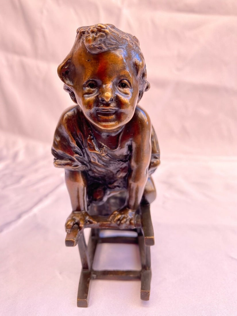 1900 Bronze Sculpture of Boy on Chair by Juan Clara: 1900 Bronze Sculpture of Boy on Chair by Juan Clara This exquisite bronze statue, crafted by renowned Spanish artist Juan Clara, depicts a boy sitting on a chair and dates back to the early 1900s. Sta