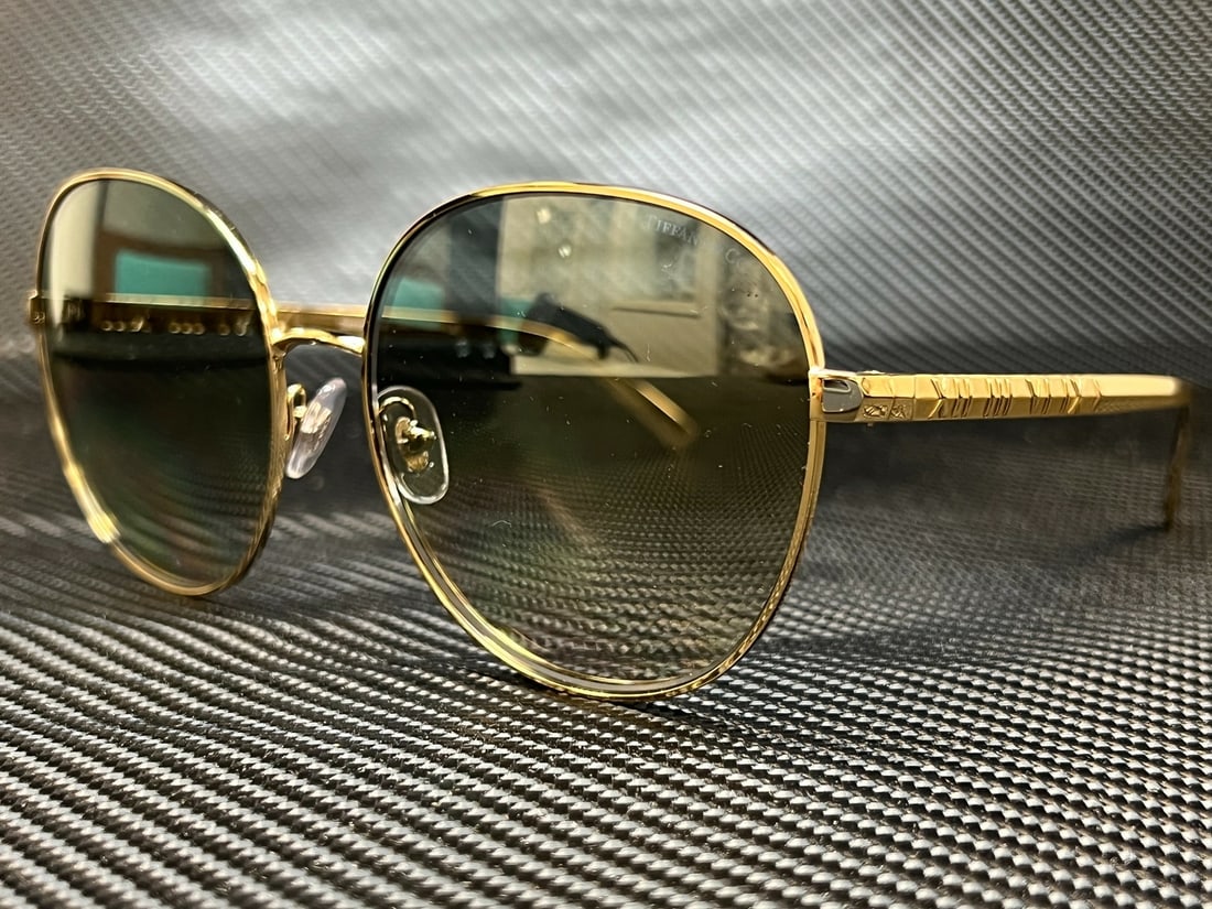 Tiffany TF3079 60mm Women's Round Sunglasses in Gold: Tiffany TF3079 60mm Women's Round Sunglasses in Gold Elevate your style with these stunning Tiffany TF3079 sunglasses, featuring a chic round design in a luxurious gold frame. Crafted by the renowned