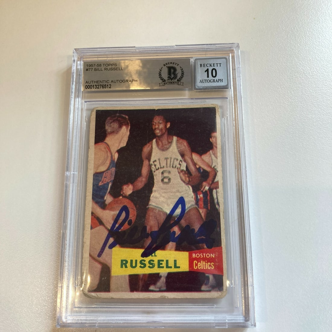 1957 Topps Bill Russell Rookie Card BGS GEM MINT 10 Autographed: 1957 Topps Bill Russell Rookie Card BGS GEM MINT 10 Autographed This 1957 Topps #77 Bill Russell rookie card is a remarkable piece of sports history, featuring a flawless blue Sharpie signature from t