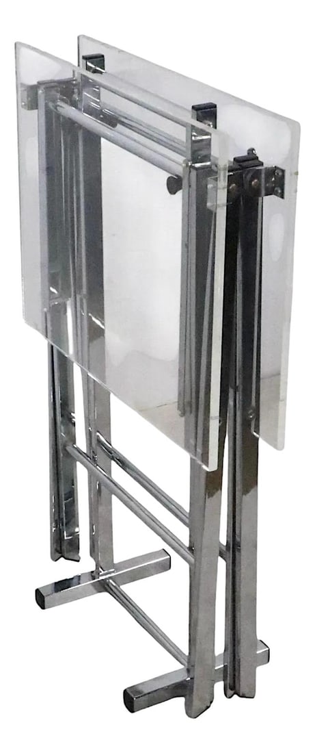 1970s Post Modern Hollywood Regency 3-Piece Lucite Chrome Folding Table Set: 1970s Post Modern Hollywood Regency 3-Piece Lucite Chrome Folding Table Set This stylish 3-piece folding table set exemplifies Post Modern Hollywood Regency design from the 1970s. Featuring a sleek ch
