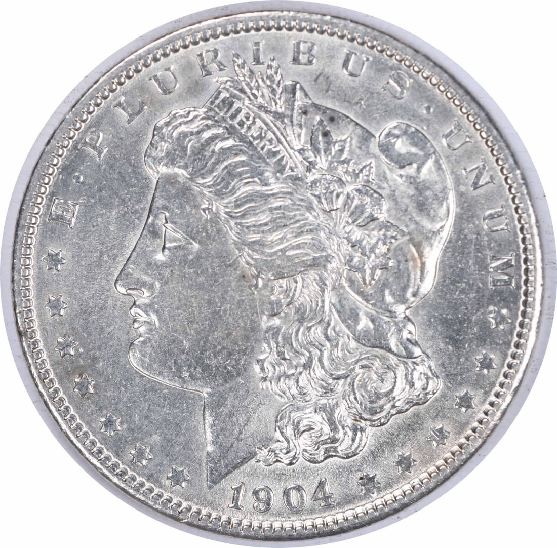 1904 Morgan Silver Dollar AU Uncertified 90% Silver Coin: 1904 Morgan Silver Dollar AU Uncertified 90% Silver Coin This 1904 Morgan Silver Dollar showcases a classic design by George T. Morgan, representing a significant piece of American numismatic history.