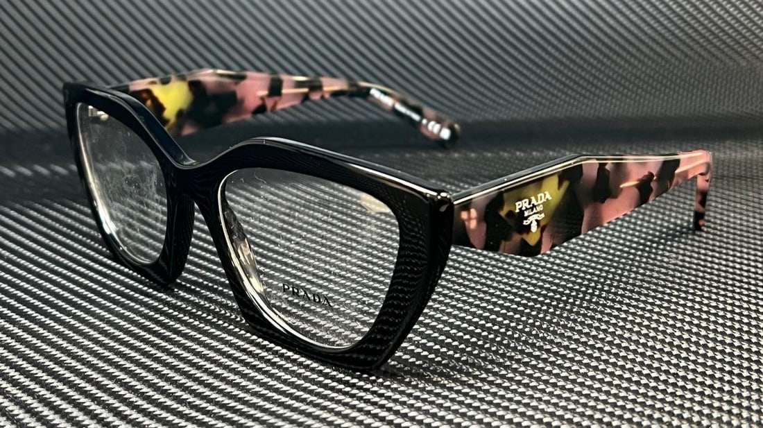 PRADA PR 09YV 21B1O1 Black Cat-Eye Eyeglasses with Original Case: PRADA PR 09YV 21B1O1 Black Cat-Eye Eyeglasses with Original Case Introducing the PRADA PR 09YV 21B1O1 Black Women's Eyeglasses, a stylish accessory that embodies a classic design with a modern touch.