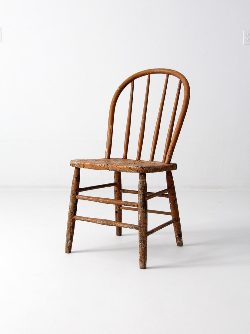 19th Century Primitive Spindle Back Chair Aged Orange Finish: 19th Century Primitive Spindle Back Chair Aged Orange Finish This exquisite 19th century spindle back farmhouse chair showcases a rare tone and primitive design. Crafted from wood, it features a disti