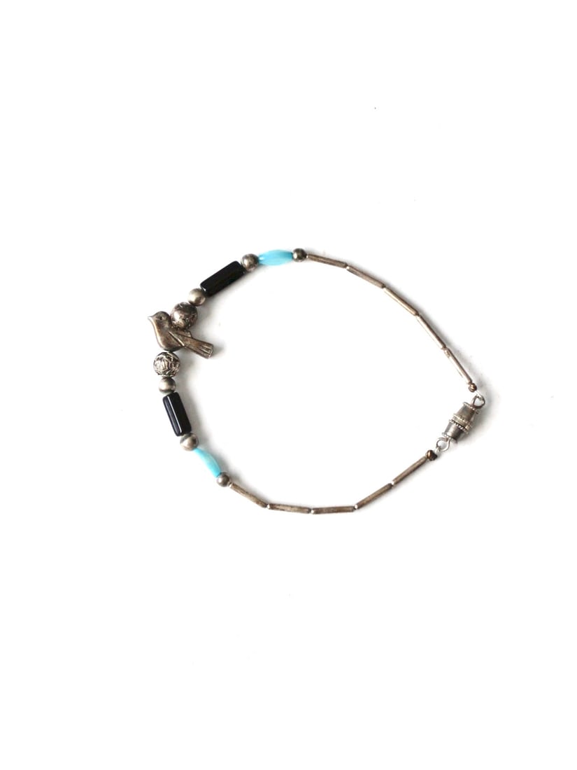 Zuni Vintage Bird Charm Bracelet with Silver Tone Beads: Zuni Vintage Bird Charm Bracelet with Silver Tone Beads This vintage bird charm bracelet features a delightful Zuni fetish style with a small metal bird charm gracefully perched among a mix of blue, s
