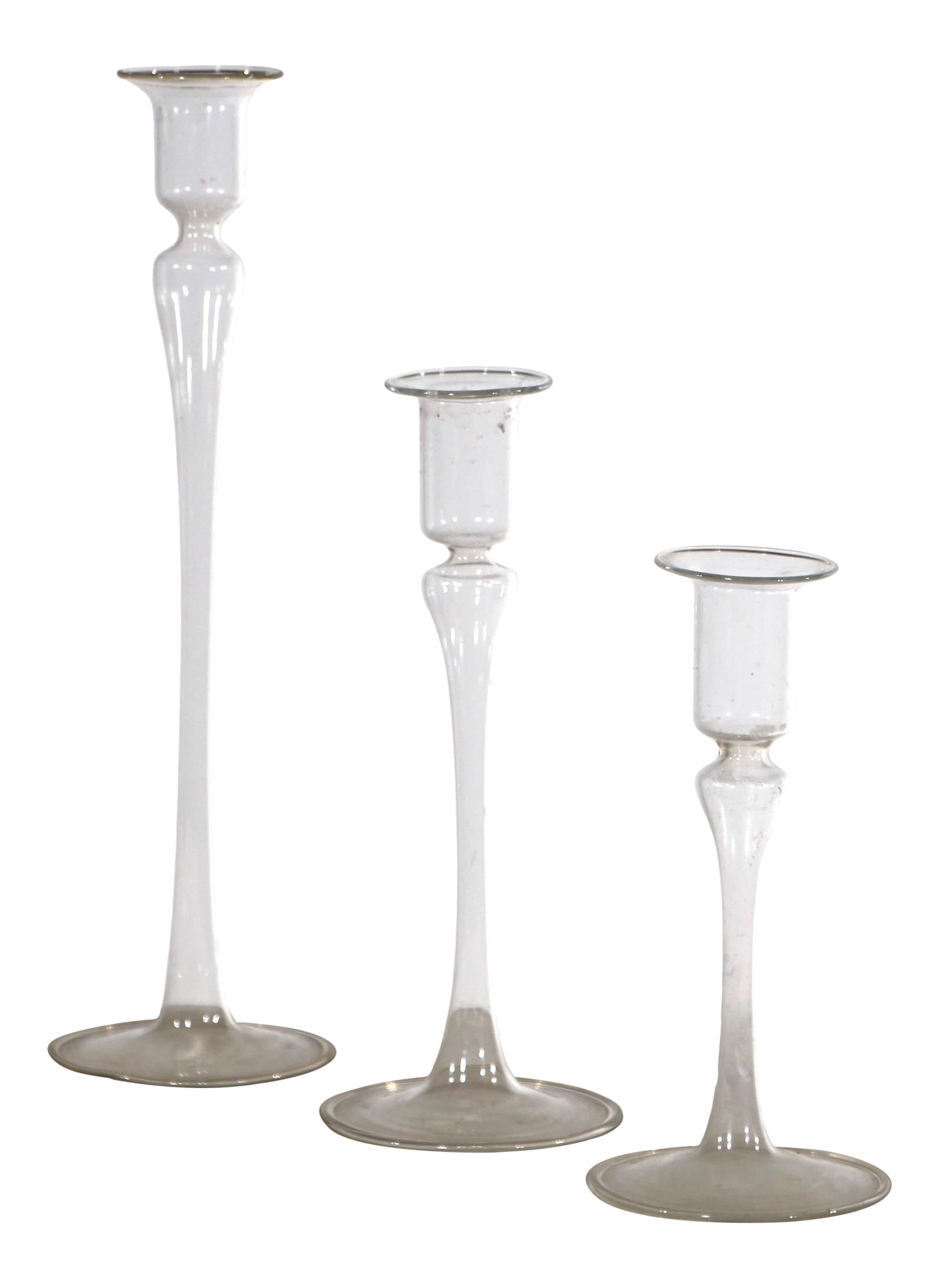 Set of 3 Dansk Attributed Blown Glass Candlesticks: Set of 3 Dansk Attributed Blown Glass Candlesticks This elegant set of three graduated candlesticks is crafted from clear blown glass, showcasing a timeless design attributed to Dansk. Each piece is i
