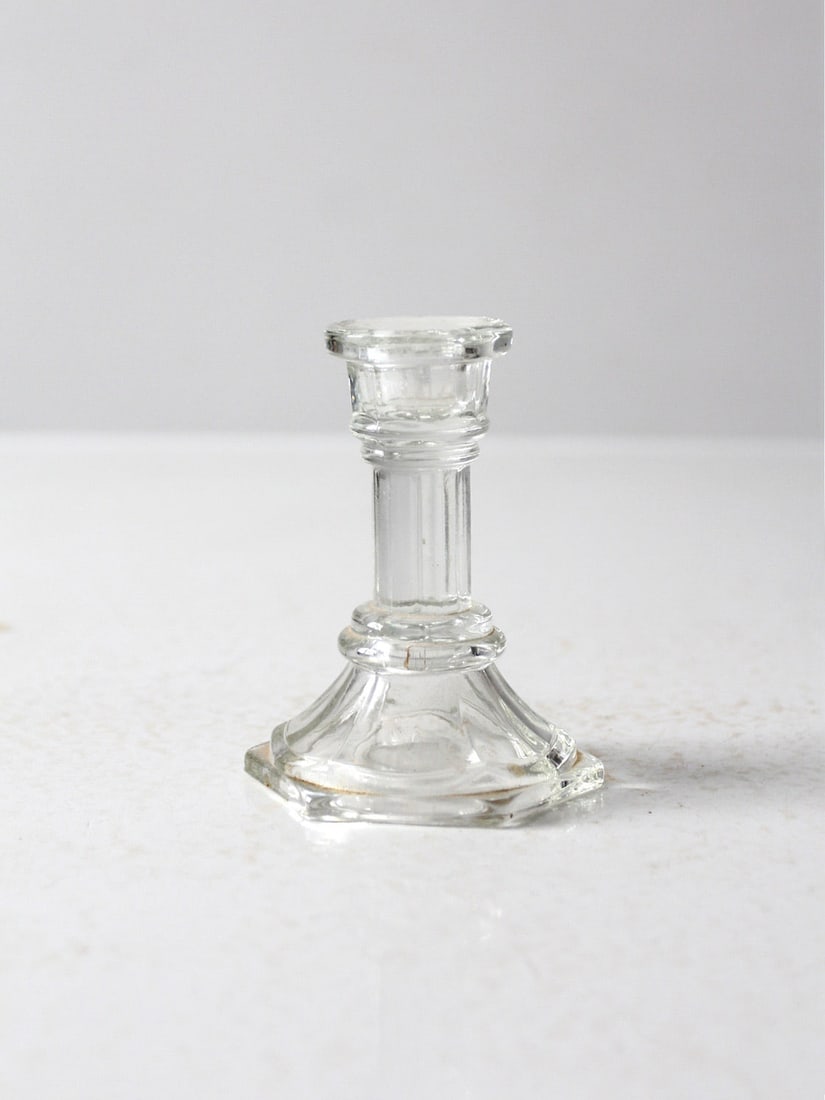Vintage Clear Glass Candlestick Holder Hexagonal Base 4.125": Vintage Clear Glass Candlestick Holder Hexagonal Base 4.125" This vintage clear glass candlestick holder showcases a timeless design, featuring a hexagonal base, a fluted neck, and a classic candle cu