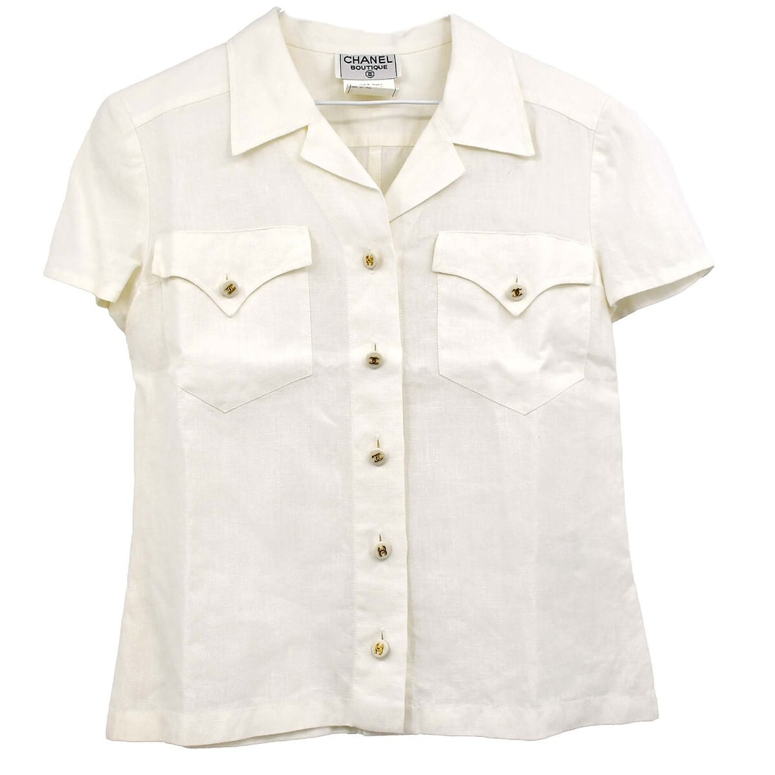 Vintage Chanel White Linen Short Sleeve Shirt Size 38: Vintage Chanel White Linen Short Sleeve Shirt Size 38 This vintage Chanel short sleeve shirt is crafted from 100% linen, making it an ideal choice for casual occasions. The shirt features a classic bu