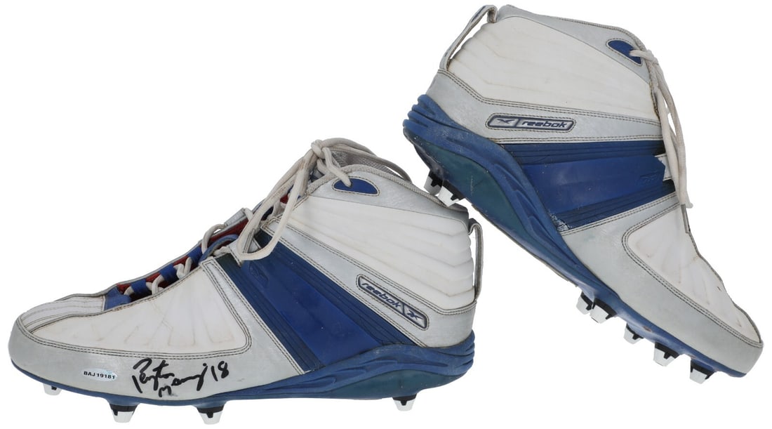 Peyton Manning Signed Game-Used Reebok Football Cleats with UDA COA: Peyton Manning Signed Game-Used Reebok Football Cleats with UDA COA This pair of game-used Reebok football cleats, worn by Hall of Famer Peyton Manning, showcases a striking gray and blue colorway. Th