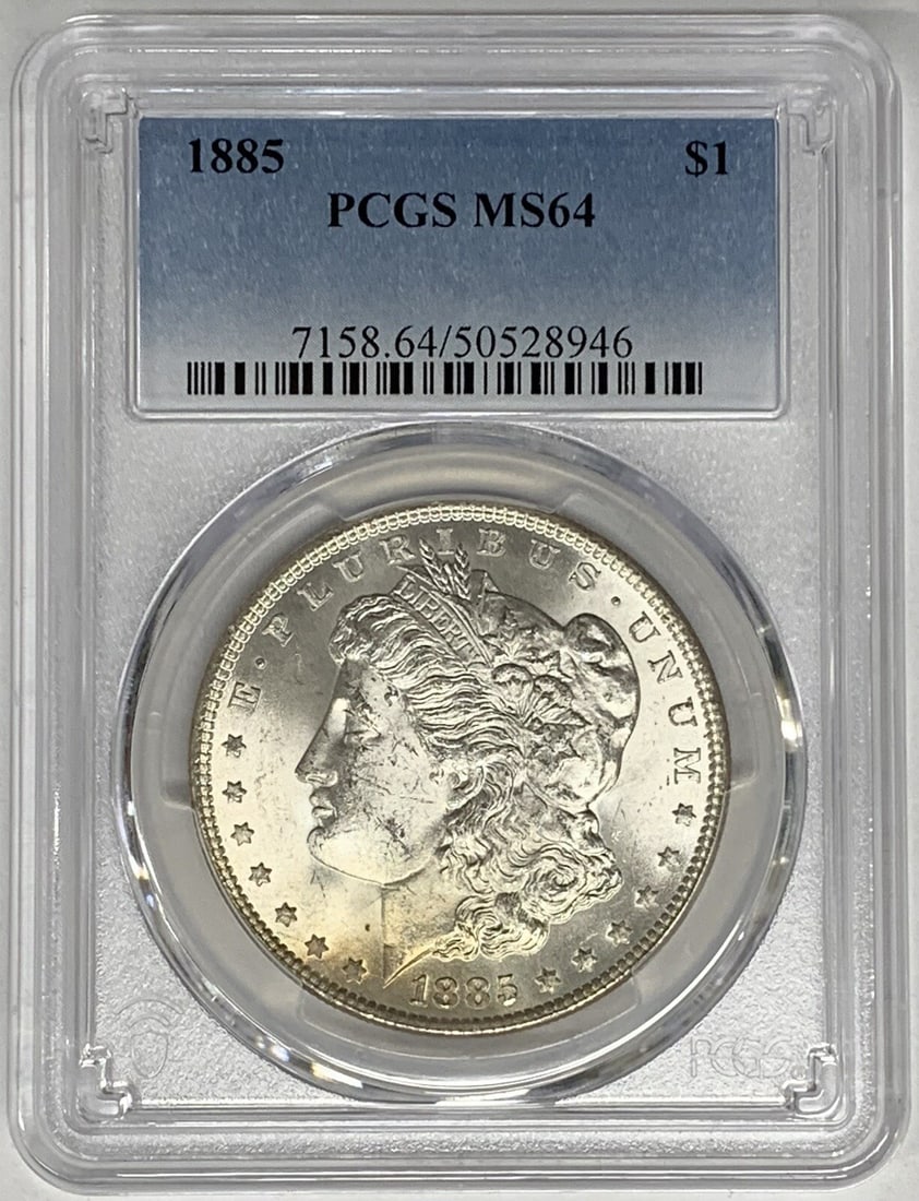1885 Morgan Silver Dollar PCGS MS 64 Uncirculated Coin: 1885 Morgan Silver Dollar PCGS MS 64 Uncirculated Coin This 1885 Morgan Silver Dollar showcases a denomination of $1 and is recognized for its uncirculated condition, graded MS 64 by PCGS. Crafted fro