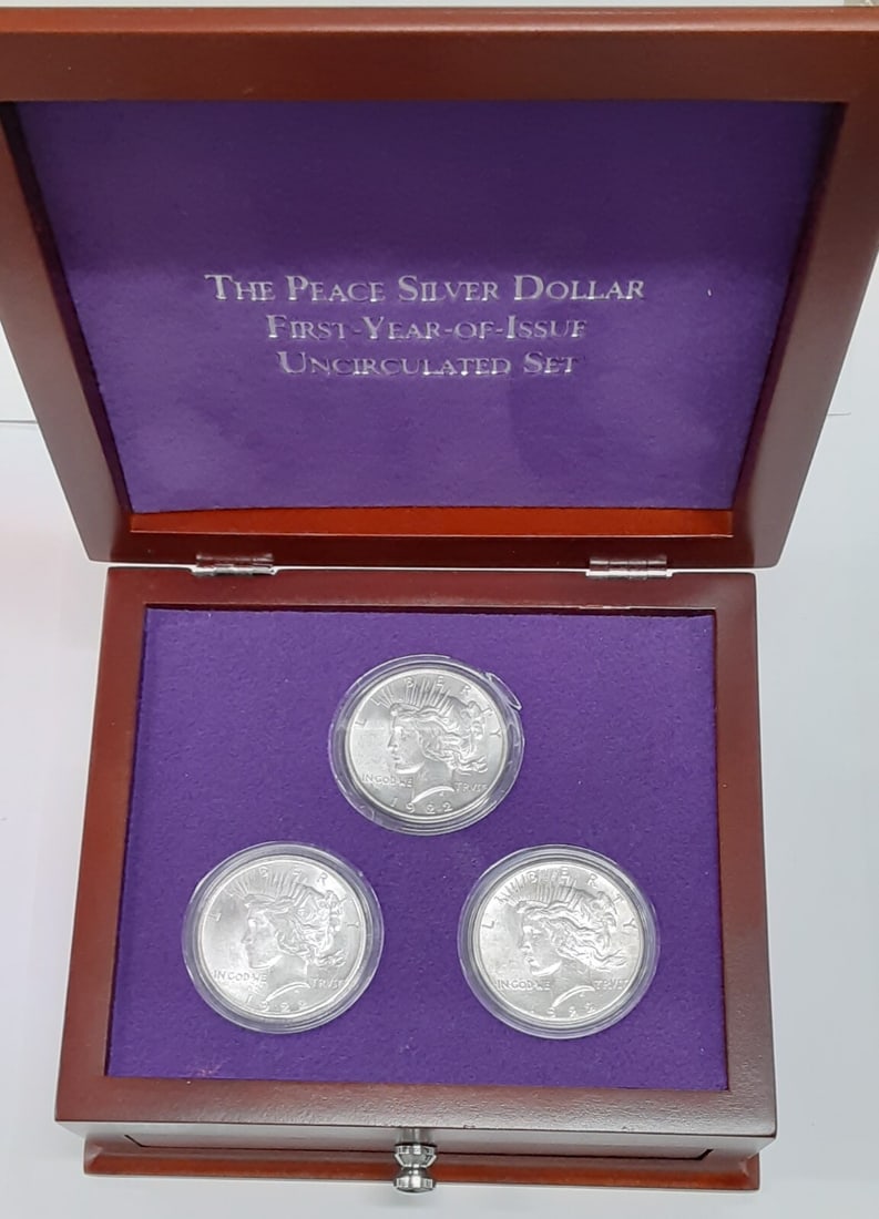 1922 US Peace Silver Dollar Set P D S in Display Case: 1922 US Peace Silver Dollar Set P D S in Display Case This set features three 1922 Peace Silver Dollars, each with a denomination of $1. The coins are made of 90% silver, showcasing their fine craftsm