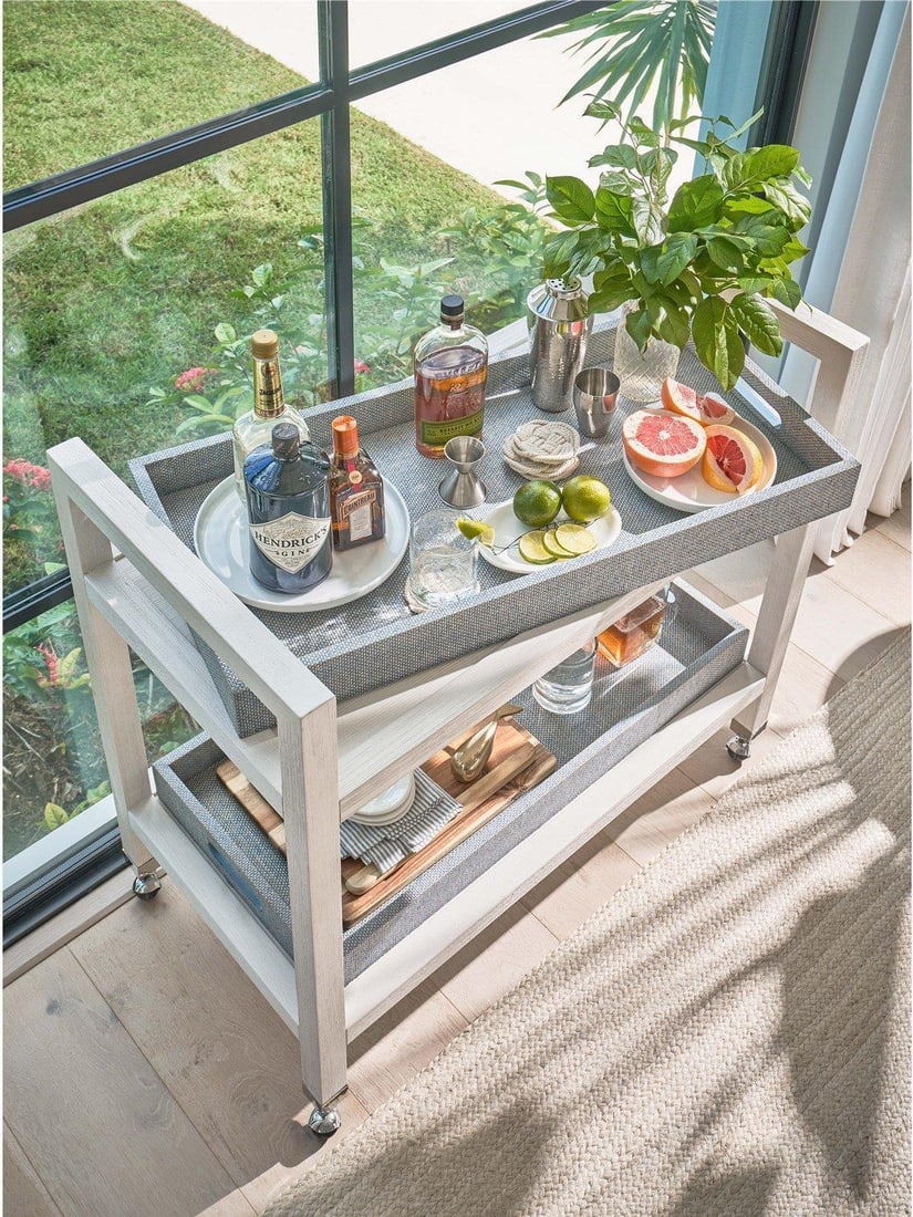 Universal Jupiter Bar Cart White Sand Finish Coastal Decor: Universal Jupiter Bar Cart White Sand Finish Coastal Decor Elevate your entertaining space with the Jupiter Bar Cart, designed to complement coastal decor. This stylish bar cart features a chic White