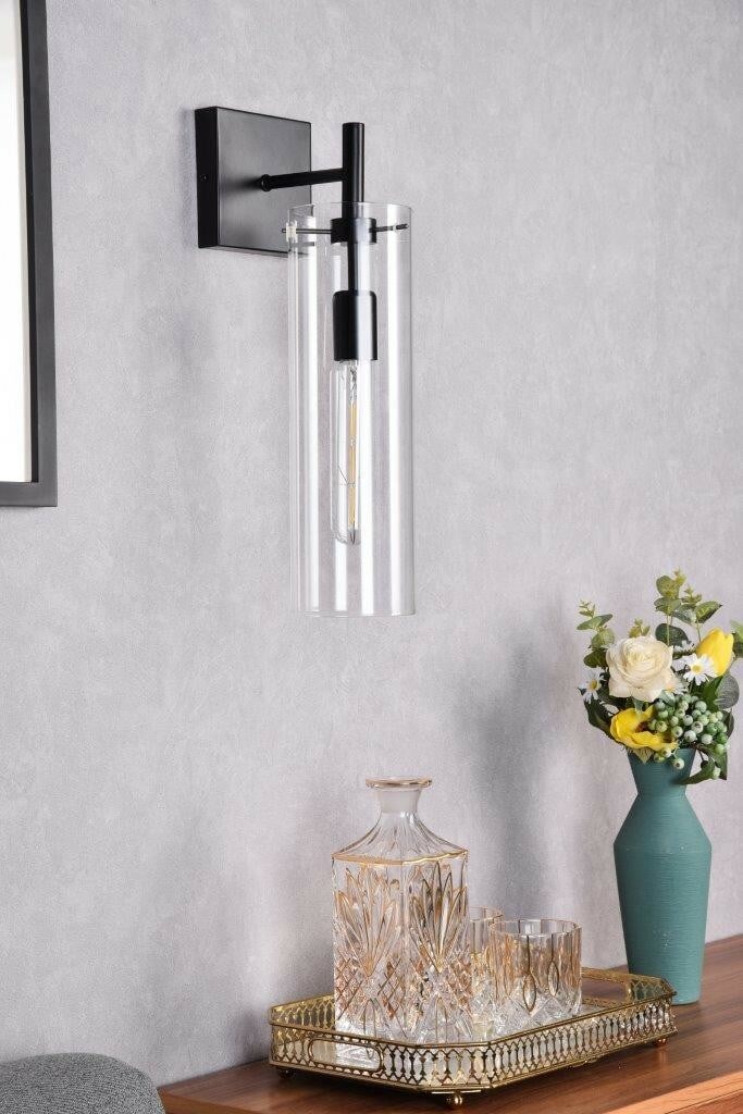 Savant Modern Black Wall Sconce with Clear Glass Shade: Savant Modern Black Wall Sconce with Clear Glass Shade Illuminate your space with this modern wall sconce featuring a sleek black metal finish and a clear glass shade. Designed to provide versatile li