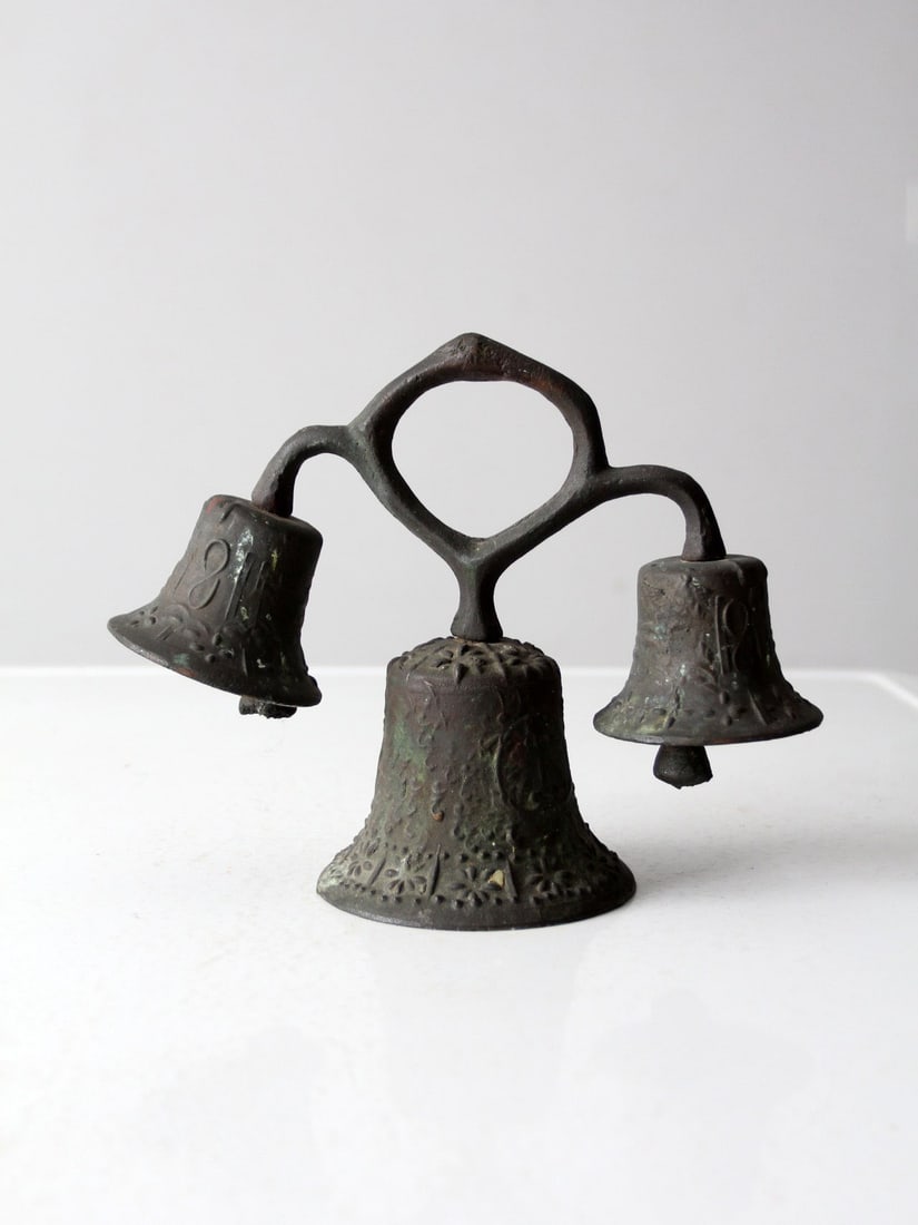 Antique 19th Century Mission Style Triple Bell Cast Iron Decor: Antique 19th Century Mission Style Triple Bell Cast Iron Decor This antique cast iron triple bell showcases a unique 19th-century mission or monastery style, characterized by its aged surface and scul