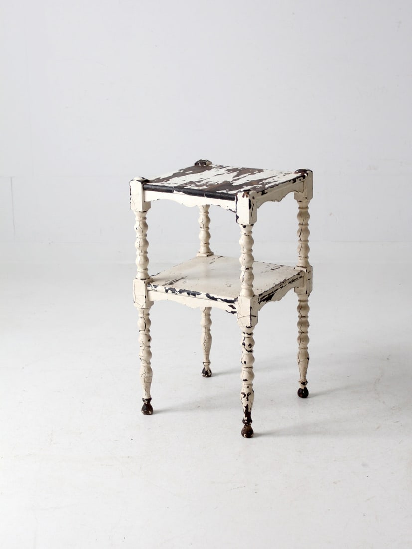 Antique Distressed White Side Table with Turned Legs: Antique Distressed White Side Table with Turned Legs This antique wooden side table features a charming white distressed finish, adding a vintage touch to any room. The elegant turned legs enhance its