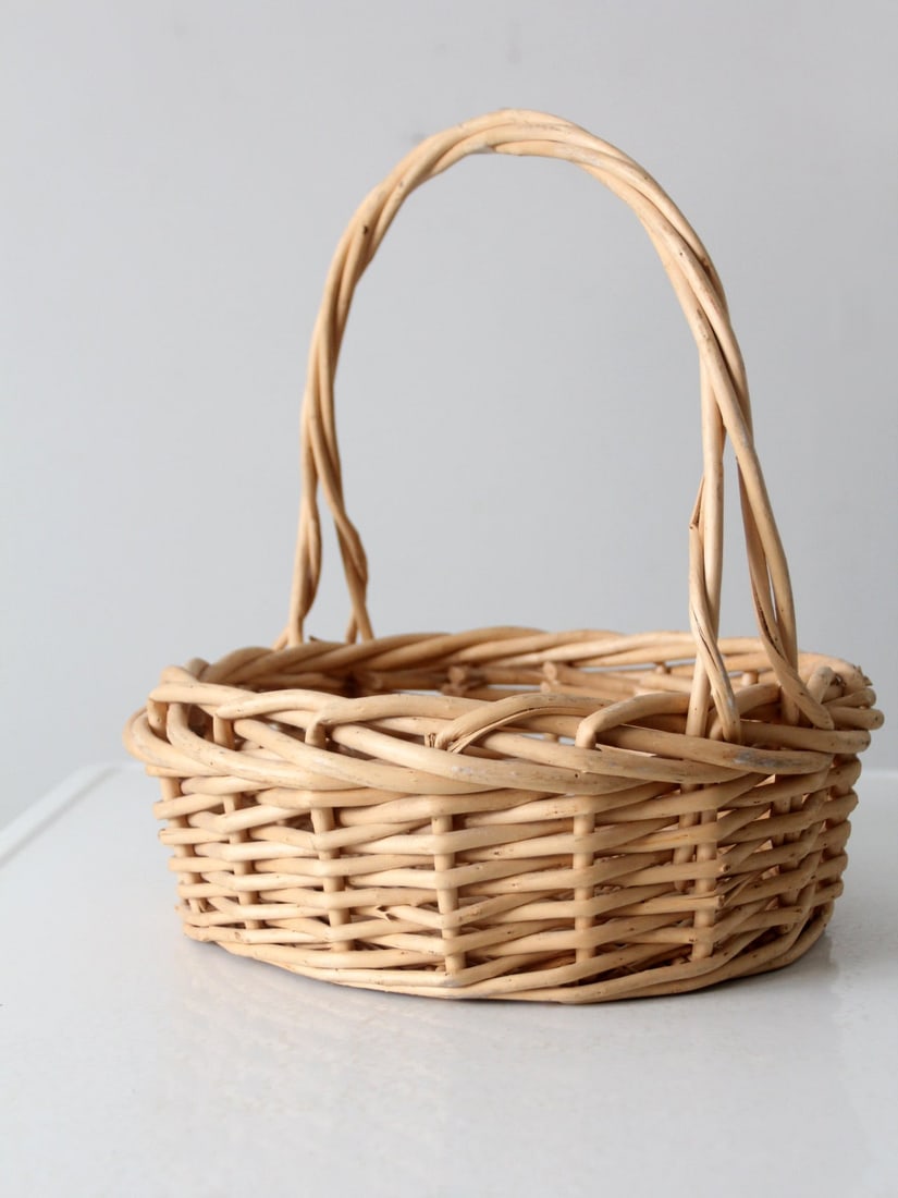 Vintage Woven Wicker Harvest Basket with Twisted Handle: Vintage Woven Wicker Harvest Basket with Twisted Handle This vintage woven wicker basket showcases a classic harvest design, complete with a twisted handle and intricate weaving. It serves as a stylis